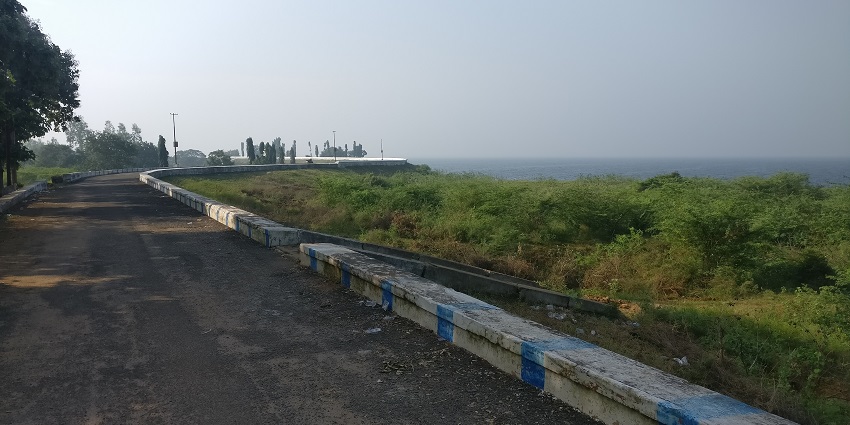 The picture of the way to the Poondi Reservoir in Tamilnadu is surrounded by greenery.