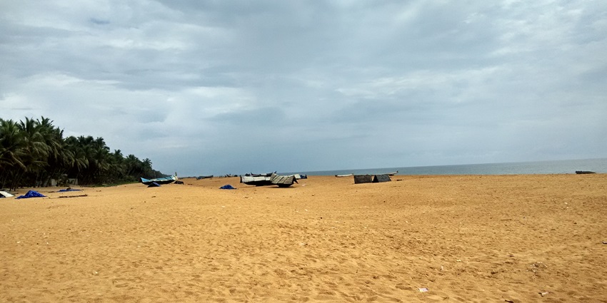 A serene view of Puthenthope Beach, a beach near Nagercoil, featuring soft golden sands and lush greenery.