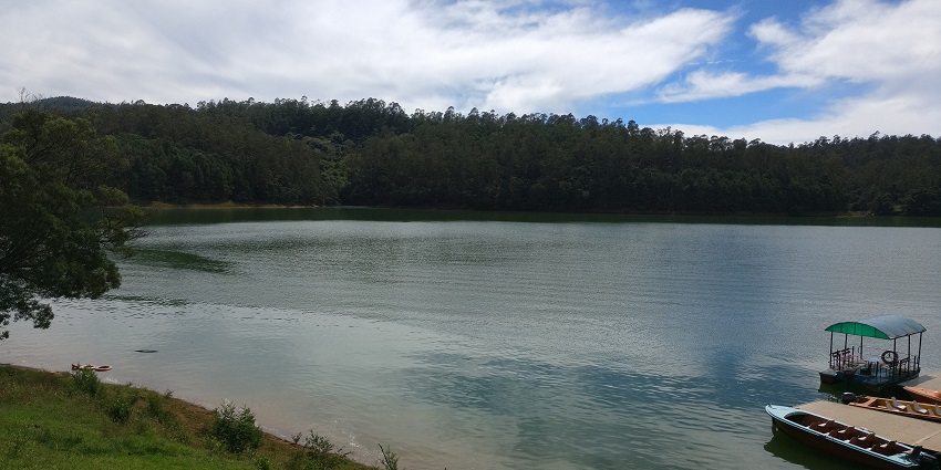 A beautiful lake, with people enjoying gentle boat rides in the warm, colourful glow