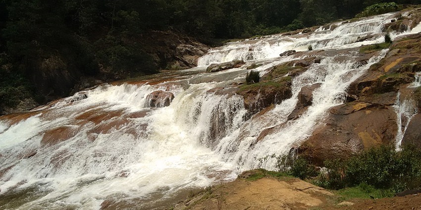 Pykara Waterfalls, the best place near Mudumalai National Park, cascading down rocky cliffs, surrounded by lush greenery and a tranquil natural setting.