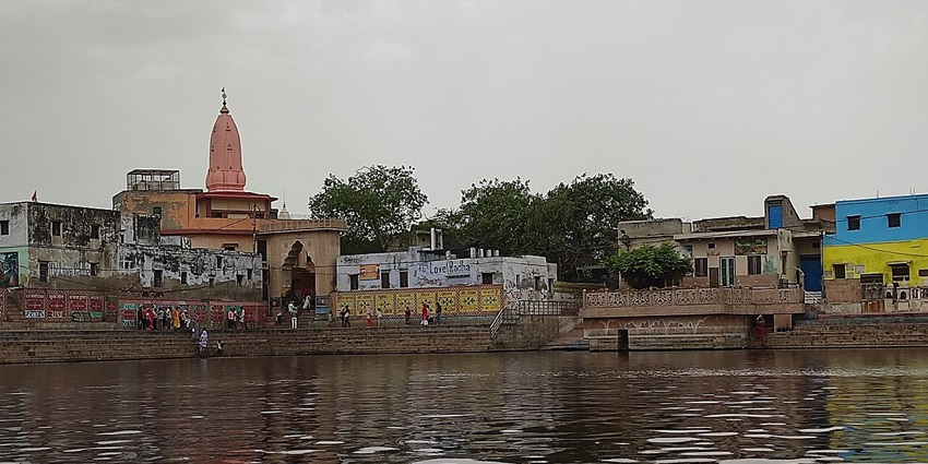 Image of Radha Kund, a famous place to visit - surrounded by building and water in the area