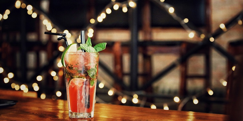 Image of a beverage with straw and lights on the background - celebrate new year party