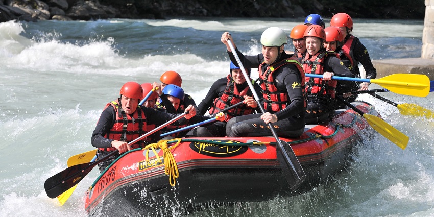 A glimpse of rafting, a thrilling adventure navigating through rapids on inflatable rafts.
