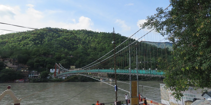 Suspension bridge connecting temples and bustling Rishikesh markets.
