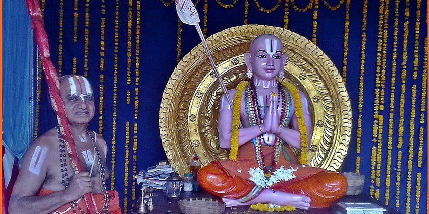 Image of a statue of Ramauja with pandit ji in a temple - Ramanuja’s Revelation