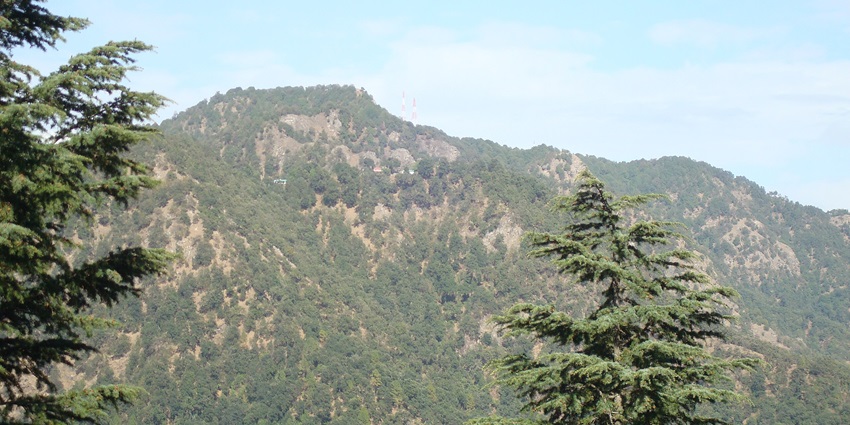 Scenic view of Ramgarh hills with lush greenery and distant Himalayan backdrop.