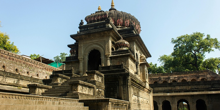 An image showing grey concrete temples under a cloudy sky like Rangaji Temple.
