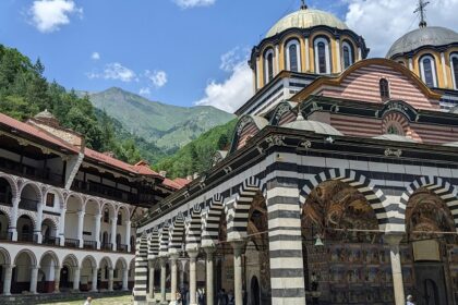 Rila monastery entrance with detailed architecture and people entering the monastery.