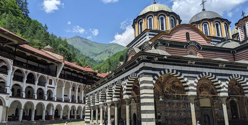 Rila monastery entrance with detailed architecture and people entering the monastery.