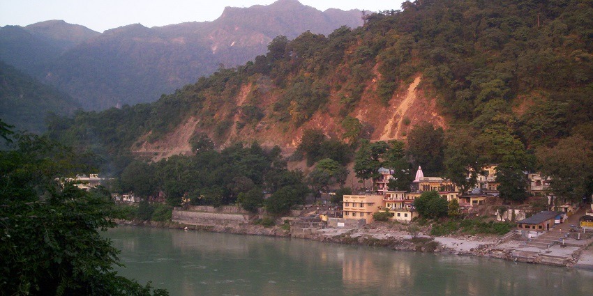 A view of the Ganga River flowing through serene ghats of Rishikesh