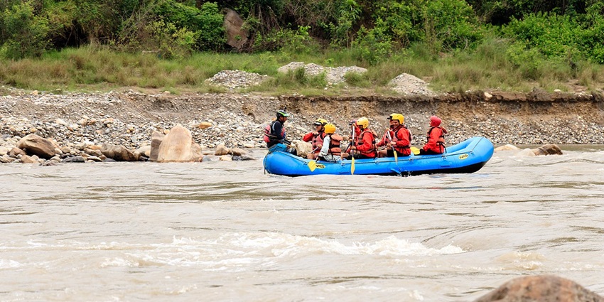 Thrilling adventure sports in Rishikesh navigating rapids on a scenic river.