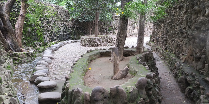 A picture of the Rock Garden located near the Wagheshwar Temple having tall trees all around