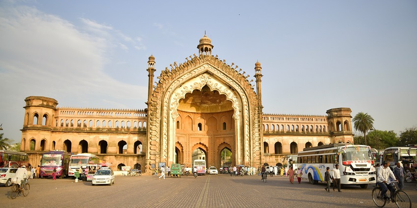 Majestic arched gateway with intricate Mughal architecture set against a bright, open sky