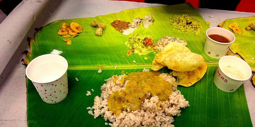 Traditional feast served on banana leaves, featuring diverse dishes for travellers.