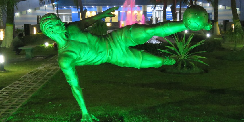 A statue of a boy playing football; situated in Salt Lake Stadium in Kolkata.