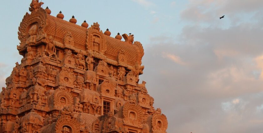 Tall and intricately carved Gopuram of Brihadisvara Temple against pink-blue sky