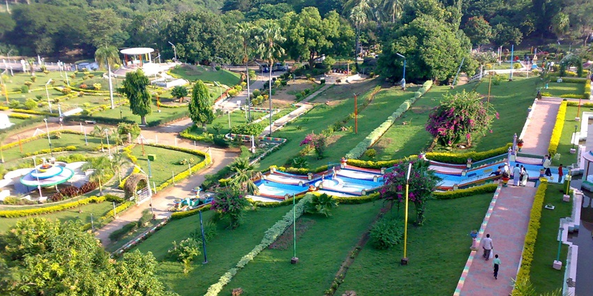 Sathanur Dam Park displays various fountains with lush greenery surrounding the background.