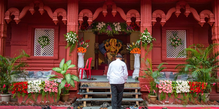 A picture of a Ganesha Temple with a devotee entering the temple to seek blessings