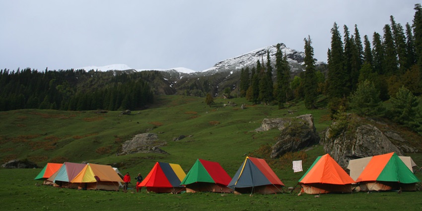 Image of camping area and tents - Thrilling adventure camp offering activities like rafting and trekking