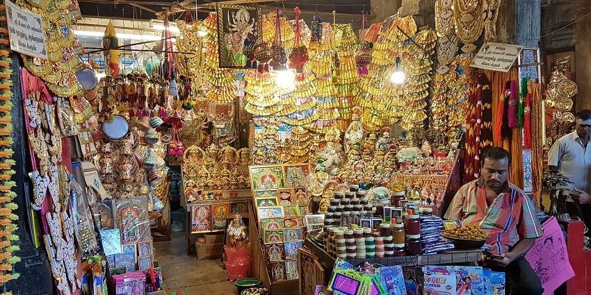 The bustling bazaar inside the Meenakshi Temple, the best place in Madurai, features vibrant stalls and devotees engaged in prayer and shopping.