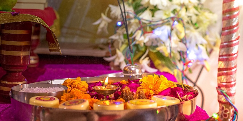 Traditional Hindu pooja thali adorned with colorful offerings, diya, and flowers for rituals