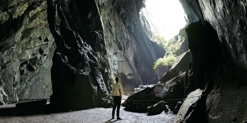 A man sitting inside a cave is among the popular destinations near Agaya Gangai Waterfall.