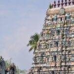 A distant view of a South Indian temple whose outer structure has intricate carvings.