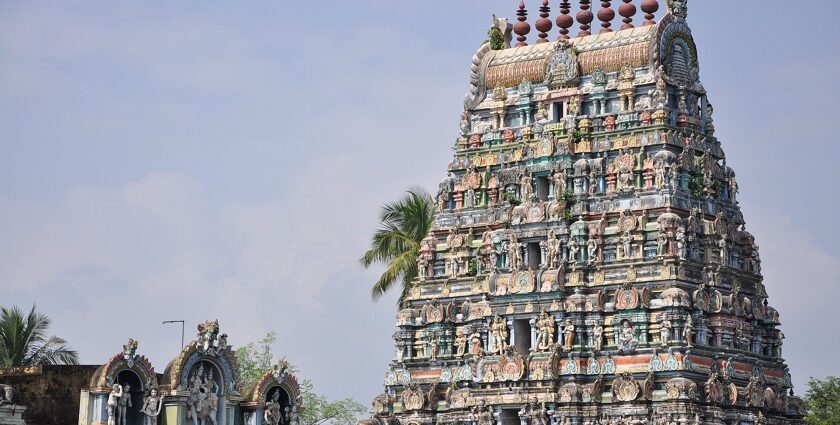 A distant view of a South Indian temple whose outer structure has intricate carvings.