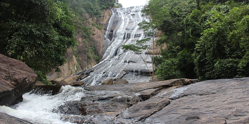 Majestic multi-tiered Kirindi Ella waterfall cascading amid lush Sri Lankan hills–Maruthamalai temple