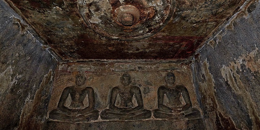Inside the rock-cut Jain temple with ancient Jain sculptures carved into the walls.