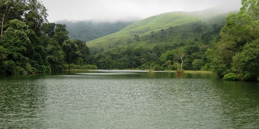 Pamba Dam with the lake surrounded by lush green hills and forests covered with fog