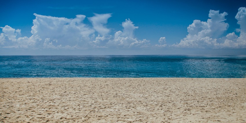 A stunning ocean view during daylight, featuring clear blue waters, creating a serene coastal atmosphere.