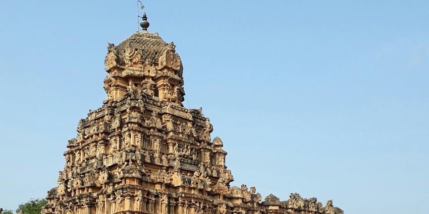 Facade of a Hindu temple with intricate carvings, towering spires, and traditional architecture.