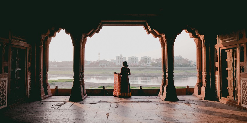 A stunning view of a woman in traditional dress at an ancient temple, part of places for Srirangam visits.