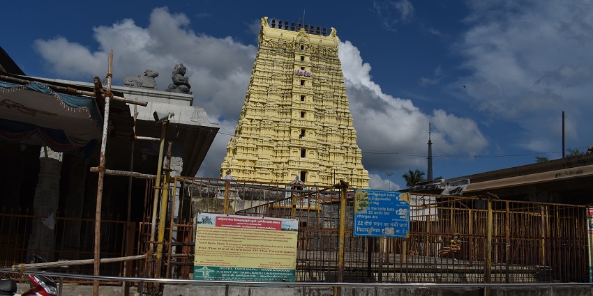 Front view of Ramanathaswamy Temple with railing surrounding the temple and a clear sky
