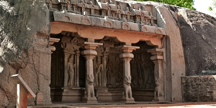 Sri Karumari Amman Alayam temple with ornate sculptures and yellow pillars at dusk.