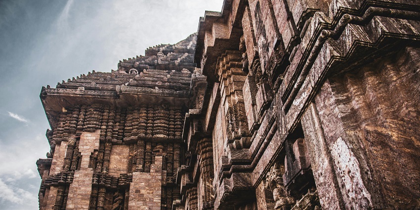 An exterior view of an Sri Kongalamman Temple adorned with stone carvings and sculptures