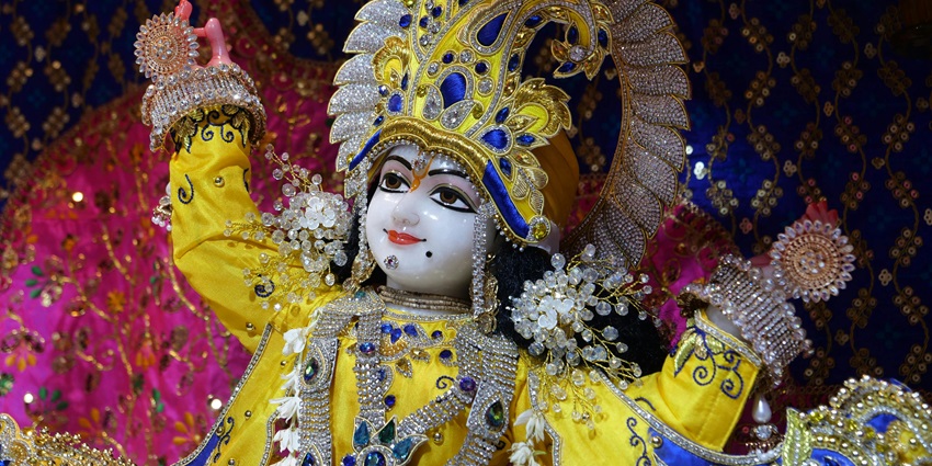 Lavishly decorated statue of Deity Krishna, showcasing intricate details and vibrant colors