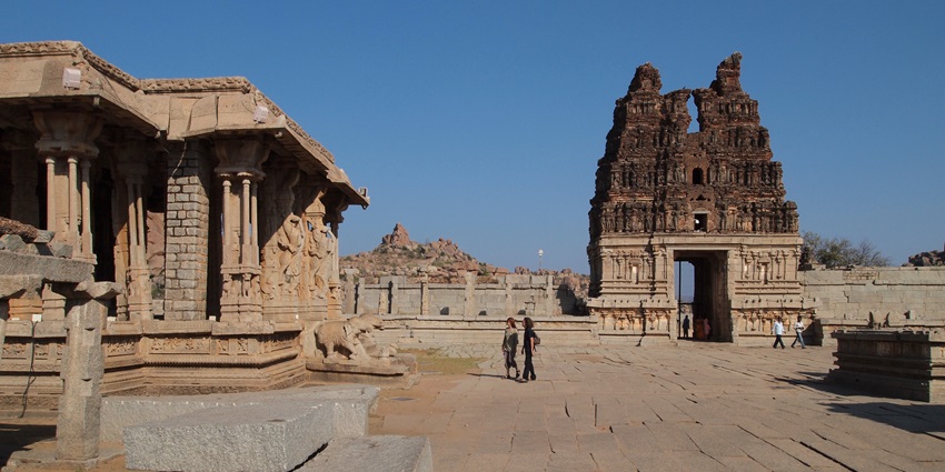 The ruins of the ancient temple tower with intricate carvings, set against a clear blue sky.