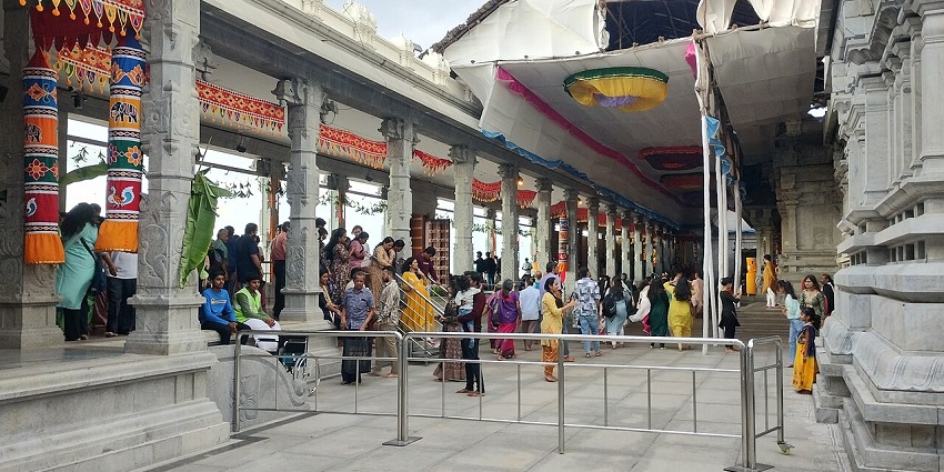 Beautiful ISKCON temple featuring grand architecture, intricate carvings, and devotees engaged in prayer
