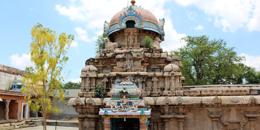 Sri Vedapureeswarar temple with intricate carvings and a colourful dome under a blue sky