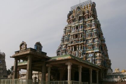 Sriperumbudur Temple with colourful gopuram, vehicles parked, and people in the foreground