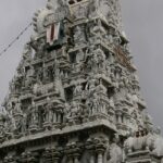 A distant view of a Srivanjiyam temple, surrounded by lush greenery