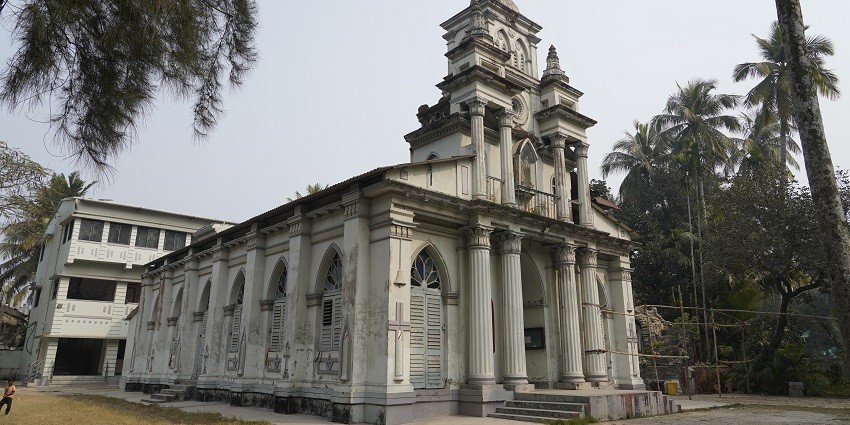 A photo of St. Joseph Catholic Church, the best place for a Srirangam trip, with a cross on top.