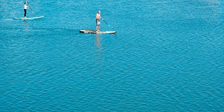 An image of a person paddle boarding, among the most amazing Juhu Beach water sports.