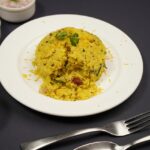 Authentic Maharashtrian dish Poha is served on a platter topped with mint leaves