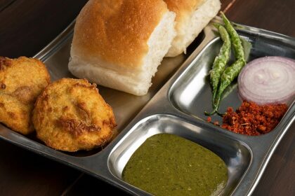 A combination of Maharashtrian food is served on a plate with other accompaniments.