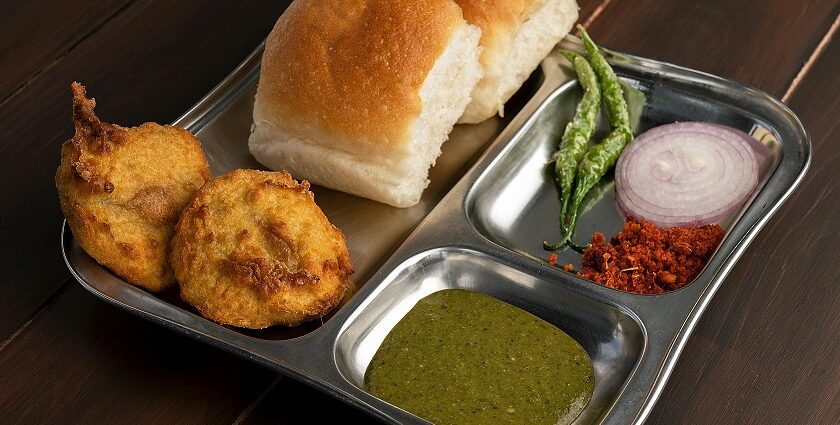 A combination of Maharashtrian food is served on a plate with other accompaniments.