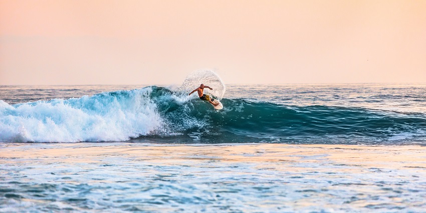 A dynamic picture showing surfers riding waves, highlighting its surfing potential