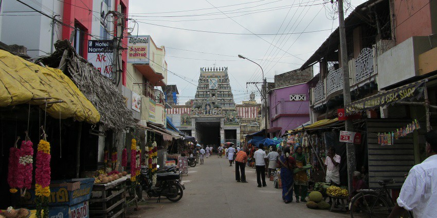 A street leading to the Swamimalai Murugan temple entrance, is surrounded by street vendors.